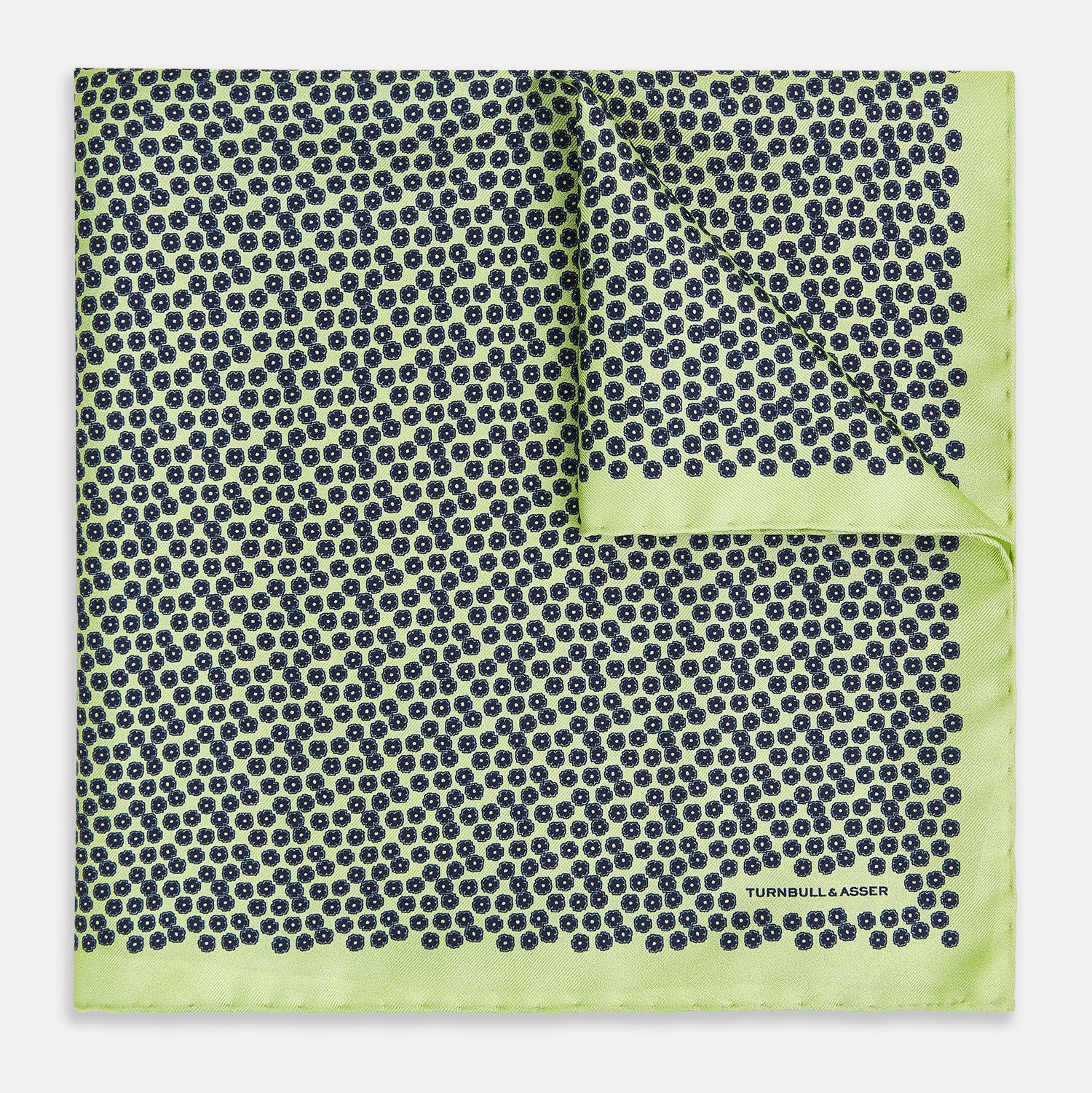 View 1 of product Introducing the Floral Green Pocket Square in Silk by Turnbull & Asser UK—a sophisticated accessory in light green silk, adorned with a delicate floral pattern and a folded corner. The pocket square features a refined double-sided design, with the Turnbull & Asser UK brand name elegantly printed on one corner.