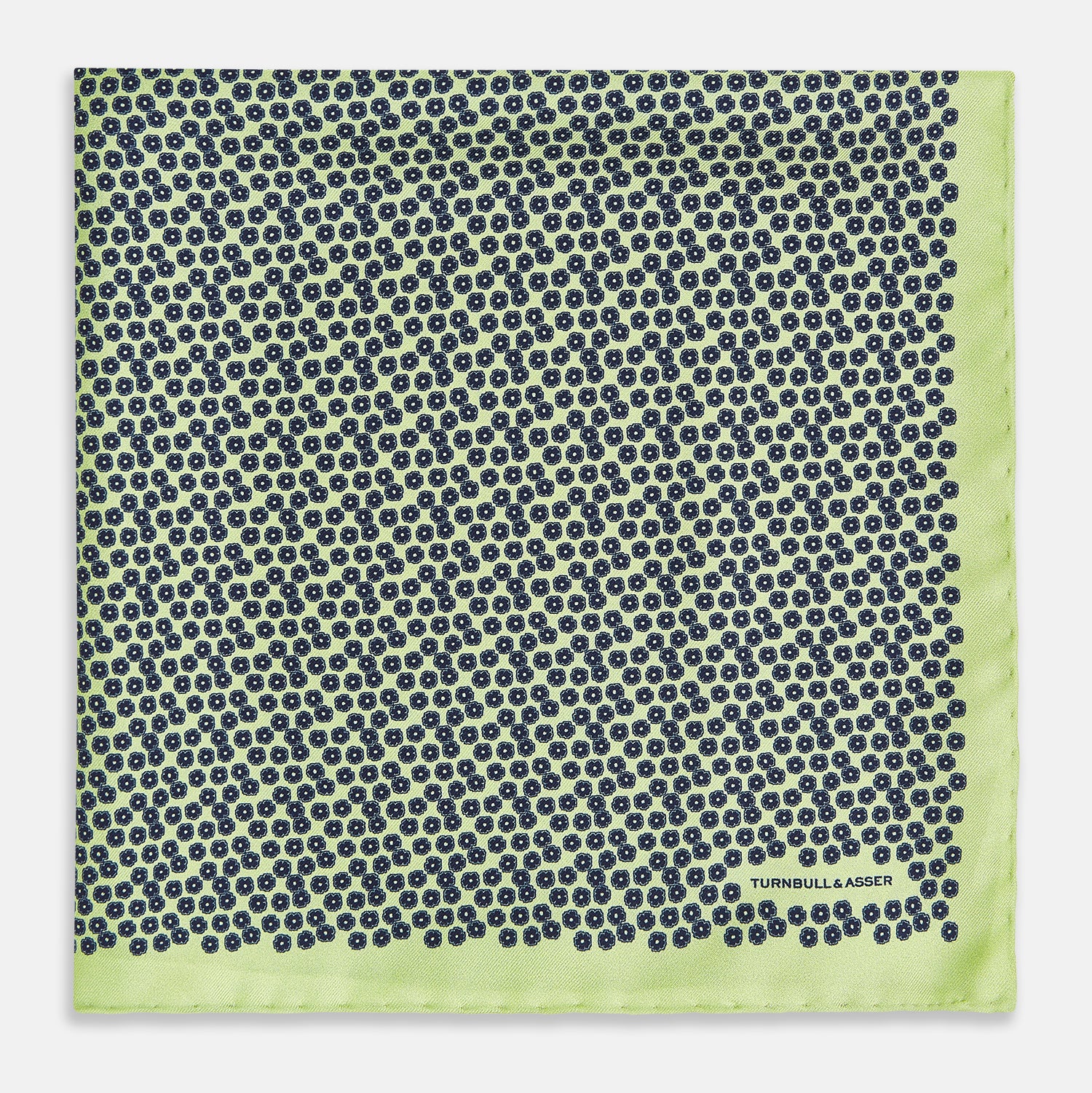 View 3 of product Introducing the Floral Green Pocket Square in Silk by Turnbull & Asser UK—a sophisticated accessory in light green silk, adorned with a delicate floral pattern and a folded corner. The pocket square features a refined double-sided design, with the Turnbull & Asser UK brand name elegantly printed on one corner.