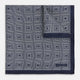 A Geometric Blue Pocket Square in Silk by Turnbull & Asser UK, featuring a navy blue and white geometric square tile design and a small label in the bottom right corner.