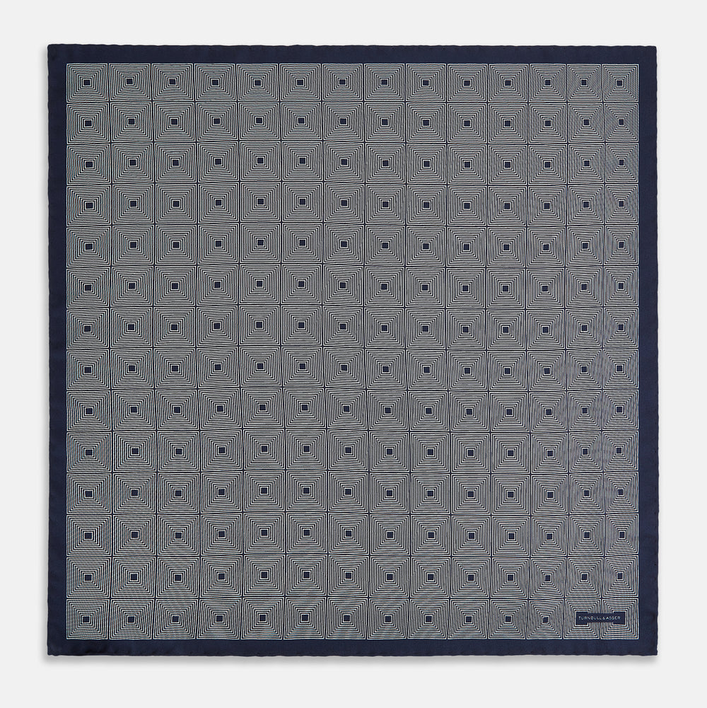 A Geometric Blue Pocket Square in Silk by Turnbull & Asser UK, featuring a navy blue and white geometric square tile design and a small label in the bottom right corner.