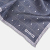 View 2 of product A folded, square Turnbull & Asser UK Geometric Grey Pocket Square in Silk featuring a geometric black and white concentric squares pattern accented with subtle navy lines, finished with a small Turnbull & Asser label in one corner.