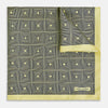 View 1 of product A checked yellow silk pocket square from Turnbull & Asser UK, featuring black and white concentric square designs with a yellow border. It is partially folded to highlight its double-sided pattern, and a small label reading TURNBULL & ASSER is visible in one corner.