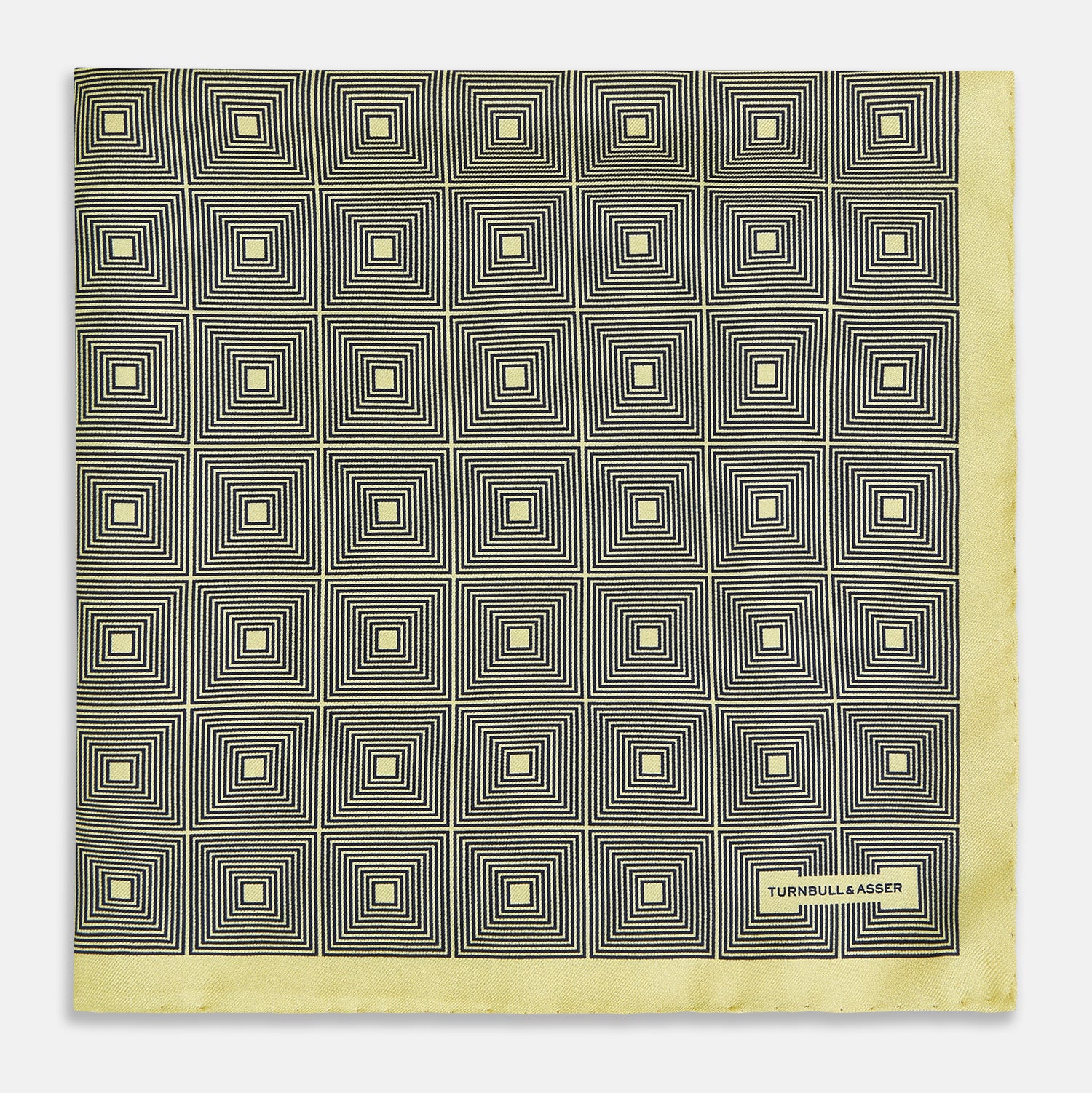 View 3 of product A checked yellow silk pocket square from Turnbull & Asser UK, featuring black and white concentric square designs with a yellow border. It is partially folded to highlight its double-sided pattern, and a small label reading TURNBULL & ASSER is visible in one corner.