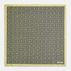 View 4 of product A checked yellow silk pocket square from Turnbull & Asser UK, featuring black and white concentric square designs with a yellow border. It is partially folded to highlight its double-sided pattern, and a small label reading TURNBULL & ASSER is visible in one corner.