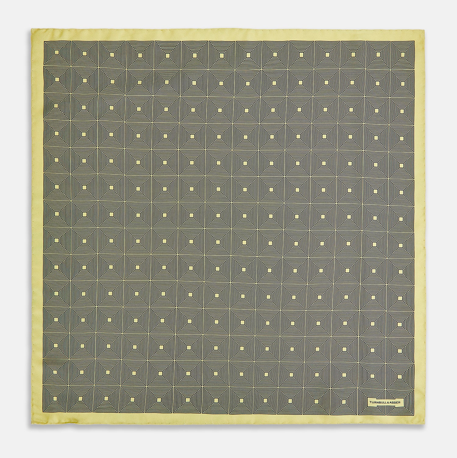 View 4 of product A checked yellow silk pocket square from Turnbull & Asser UK, featuring black and white concentric square designs with a yellow border. It is partially folded to highlight its double-sided pattern, and a small label reading TURNBULL & ASSER is visible in one corner.
