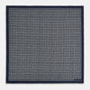 View 4 of product A Geometric Navy Pocket Square in Silk by Turnbull & Asser UK, showcasing a geometric pattern of small, overlapping concentric white squares and a stitched border. The pocket square is pictured with one corner folded over to display the Turnbull & Asser UK brand label.