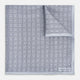 Geometric silver pocket square in silk by Turnbull & Asser UK, featuring a striking pattern of dark blue concentric squares. One corner of the fabric is folded to reveal the reverse side, with the brand name Turnbull & Asser UK printed elegantly in one corner.