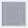 View 3 of product Geometric silver pocket square in silk by Turnbull & Asser UK, featuring a striking pattern of dark blue concentric squares. One corner of the fabric is folded to reveal the reverse side, with the brand name Turnbull & Asser UK printed elegantly in one corner.