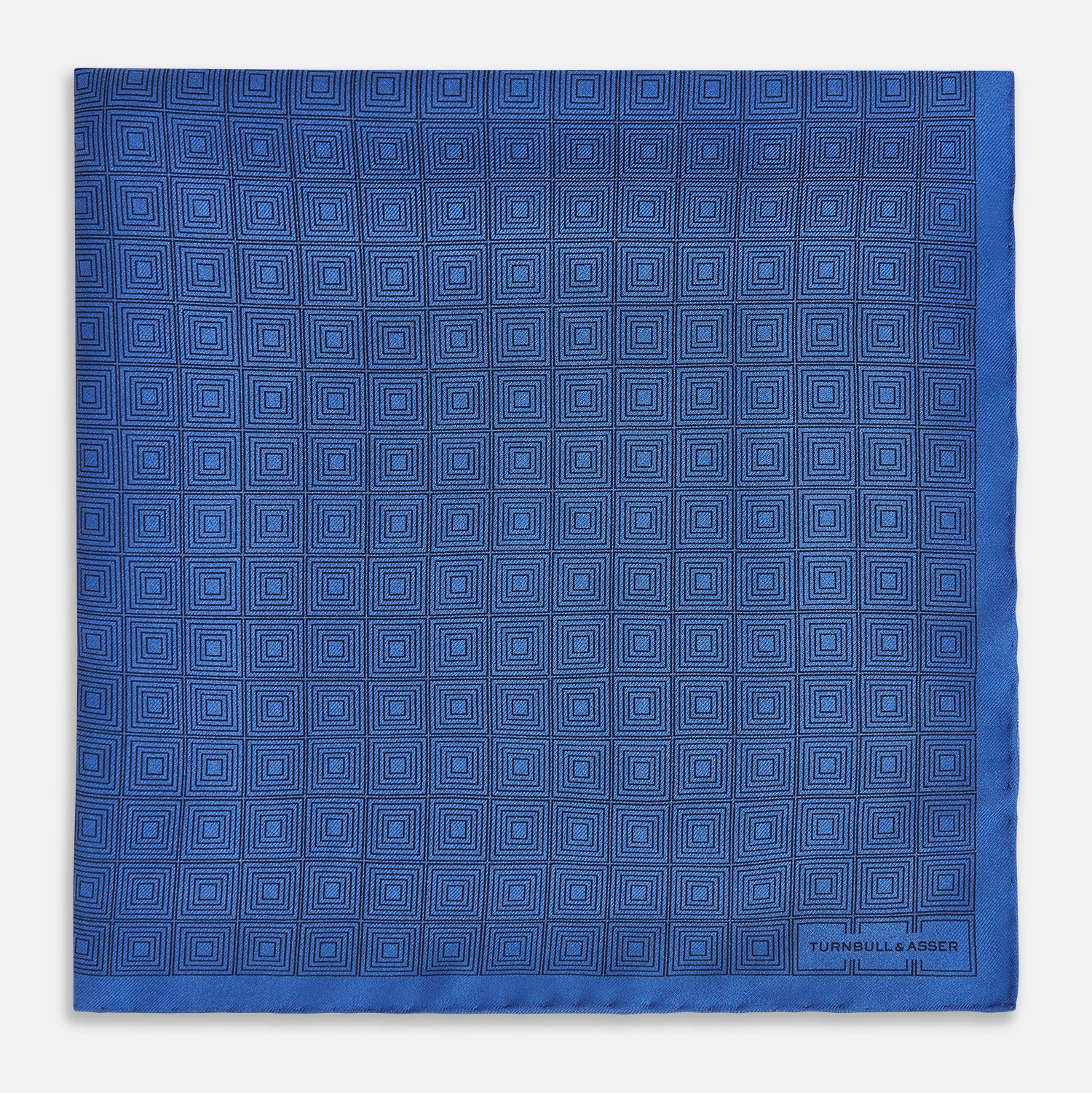 View 3 of product The Geometric Blue Pocket Square in Silk by Turnbull & Asser UK features a vibrant blue design adorned with small, outlined squares arranged in a grid of sharp navy lines. One corner is neatly folded to reveal the reverse side, with "Turnbull & Asser" printed at the bottom right.