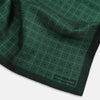 View 2 of product The Geometric Green Pocket Square in Silk by Turnbull & Asser UK features a sophisticated forest green hue with a geometric pattern of concentric squares and a visible Turnbull & Asser label in the corner.