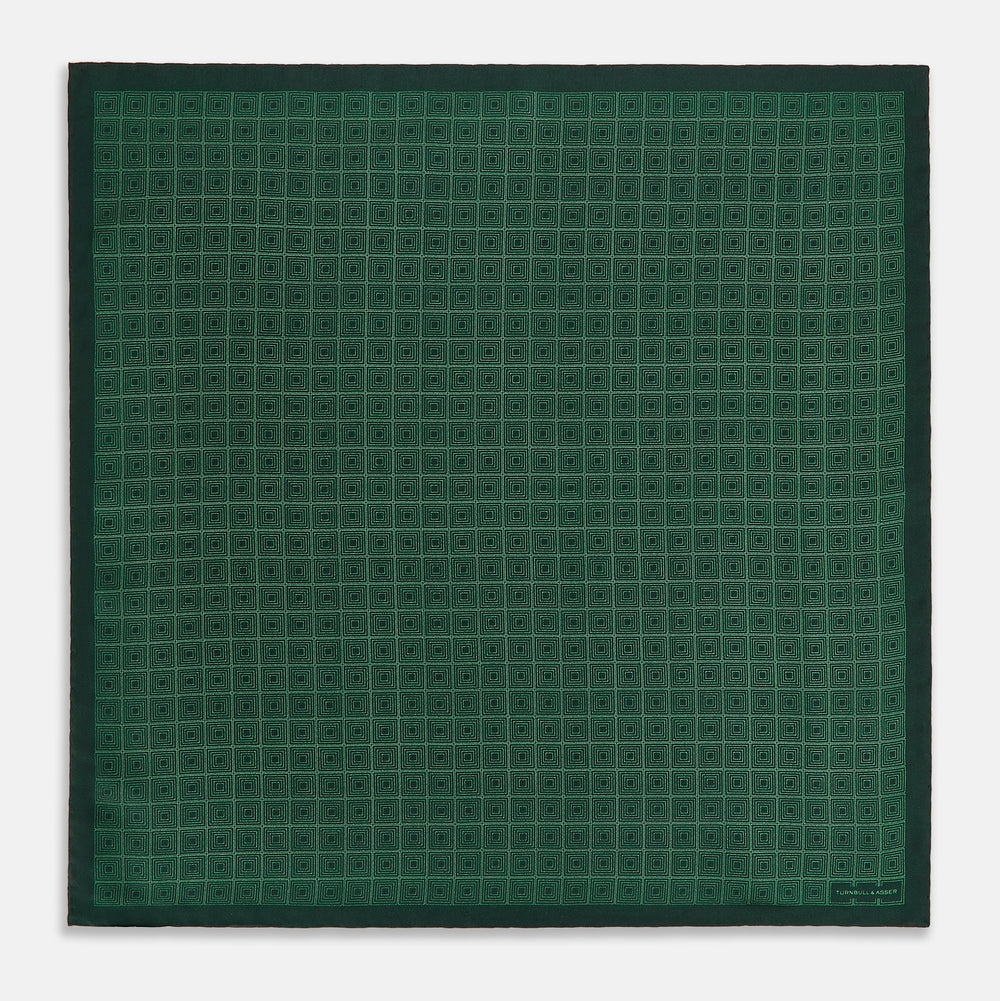 The Geometric Green Pocket Square in Silk by Turnbull & Asser UK features a sophisticated forest green hue with a geometric pattern of concentric squares and a visible Turnbull & Asser label in the corner.