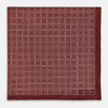 View 3 of product The Geometric Burgundy Pocket Square in Silk by Turnbull & Asser UK features a refined pattern of small, repeating white squares on a rich burgundy background—an ideal accessory for introducing sophistication to any outfit. One corner is artfully folded over to showcase the reverse side of this elegant geometric design, and the "Turnbull & Asser" label appears in the bottom right corner.