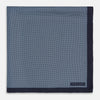 View 3 of product Introducing the Polka Dot Navy Pocket Square in Silk by Turnbull & Asser UK—this elegant accessory features a refined dot motif with small white polka dots and a solid navy border. One corner is artfully folded to reveal the underside, adding visual interest, while the Turnbull & Asser branding is printed in white on one corner, making it an ideal choice for formal tailoring.