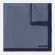 Crafted from silk, the Turnbull & Asser UK Polka dot Denim Pocket Square features a sophisticated navy blue hue adorned with small white polka dots and a solid border. Neatly folded with the brand label visible in one corner, this elegant accessory is ideal for enhancing formal tailoring.