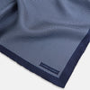 View 2 of product Crafted from silk, the Turnbull & Asser UK Polka dot Denim Pocket Square features a sophisticated navy blue hue adorned with small white polka dots and a solid border. Neatly folded with the brand label visible in one corner, this elegant accessory is ideal for enhancing formal tailoring.