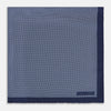 View 3 of product Crafted from silk, the Turnbull & Asser UK Polka dot Denim Pocket Square features a sophisticated navy blue hue adorned with small white polka dots and a solid border. Neatly folded with the brand label visible in one corner, this elegant accessory is ideal for enhancing formal tailoring.