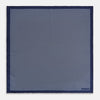 View 4 of product Crafted from silk, the Turnbull & Asser UK Polka dot Denim Pocket Square features a sophisticated navy blue hue adorned with small white polka dots and a solid border. Neatly folded with the brand label visible in one corner, this elegant accessory is ideal for enhancing formal tailoring.
