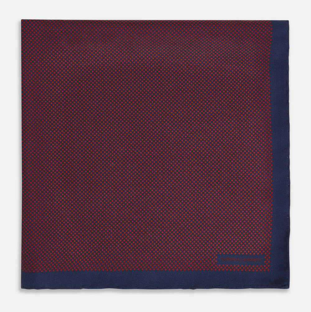 A Polka dot Burgundy Pocket Square in Silk by Turnbull & Asser UK, featuring a subtle micro motif and a solid navy border, partially folded at the top right corner.