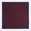 View 4 of product A Polka dot Burgundy Pocket Square in Silk by Turnbull & Asser UK, featuring a subtle micro motif and a solid navy border, partially folded at the top right corner.