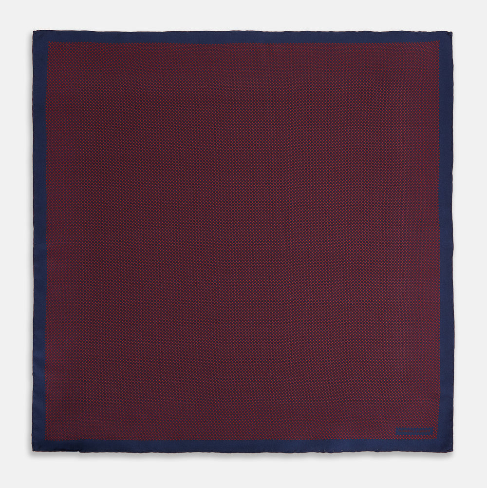 A Polka dot Burgundy Pocket Square in Silk by Turnbull & Asser UK, featuring a subtle micro motif and a solid navy border, partially folded at the top right corner.
