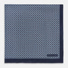 View 3 of product Introducing the Geometric Navy Pocket Square in Silk by Turnbull & Asser UK. This sophisticated accessory showcases a small, repeating geometric pattern in light blue and white on a rich navy background. The pocket square features a solid navy border, while the folded corner reveals the underside adorned with the Turnbull & Asser logo—an elegant finishing touch for any formal ensemble.