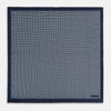 View 4 of product Introducing the Geometric Navy Pocket Square in Silk by Turnbull & Asser UK. This sophisticated accessory showcases a small, repeating geometric pattern in light blue and white on a rich navy background. The pocket square features a solid navy border, while the folded corner reveals the underside adorned with the Turnbull & Asser logo—an elegant finishing touch for any formal ensemble.