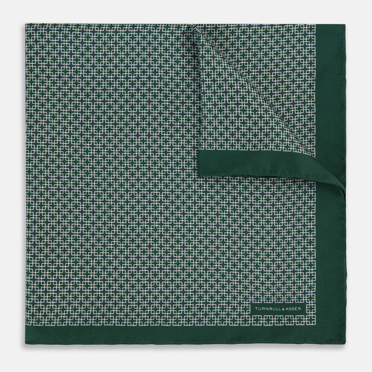 View 1 of product Turnbull & Asser UK Geometric Green Forest Green Pocket Square in Silk featuring a white geometric motif and a solid green border.