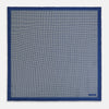 View 4 of product A blue pocket square from Turnbull & Asser UK, featuring a geometric white square pattern and a solid blue border. One corner is folded to highlight the striking design on both sides, with the brand name displayed on the bottom right. Product name: POCKET SQUARE SQUARE PATTERNED BANANA.