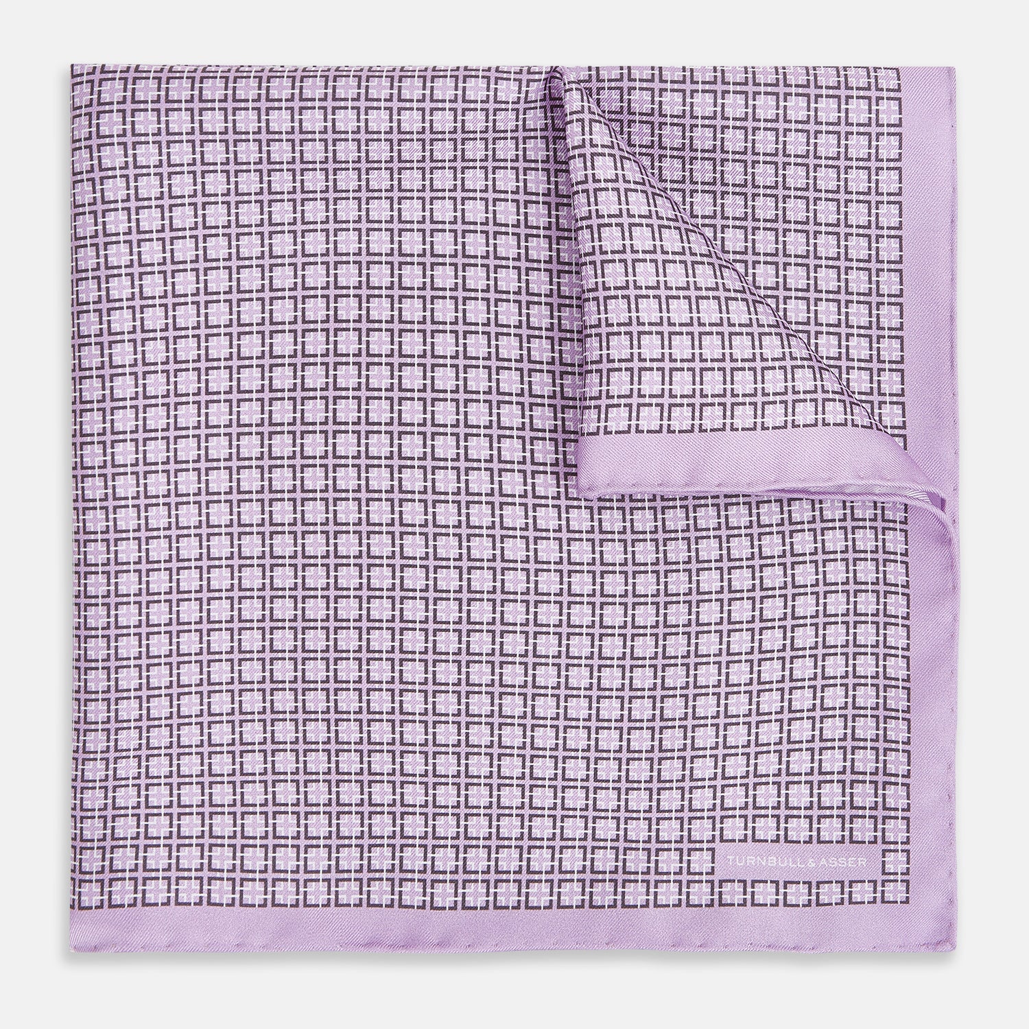 View 1 of product Crafted by Turnbull & Asser UK, the Geometric Lilac Pocket Square in Silk features an elegant square pattern in lilac hues, accented by a solid lavender border. When folded, it tastefully displays a glimpse of the sophisticated patterned underside.