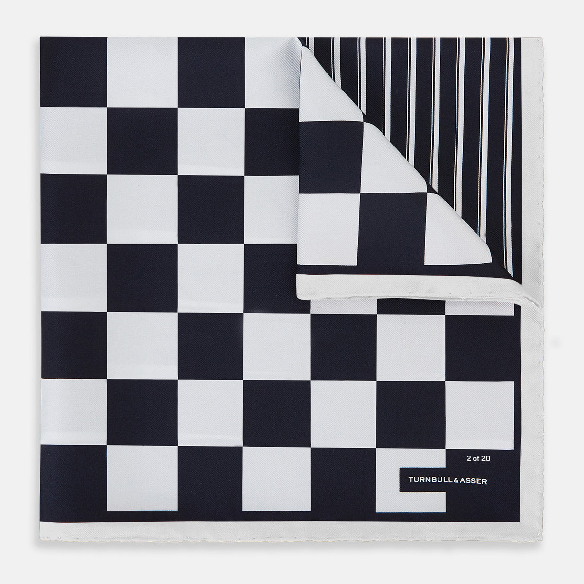 View 1 of product A square silk pocket square featuring a navy-on-white chequered pattern, labeled Turnbull & Asser UK with 2 of 20 in the bottom right corner—part of the limited edition Chequered Navy on White Frame Pocket Square from the Driver’s Capsule Collection.
