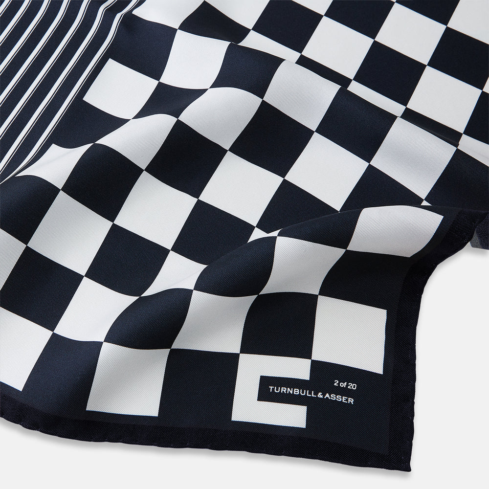 A chequered navy on navy frame silk pocket square from Turnbull & Asser UK, this piece is a limited edition from the Driver’s Capsule Collection, featuring “Turnbull & Asser” and “2 of 20” printed in one corner.