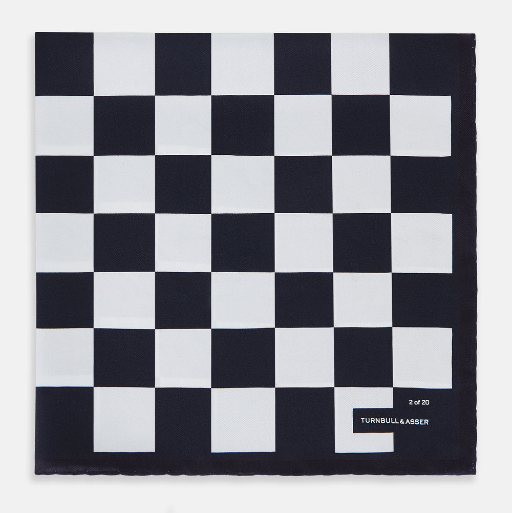 A chequered navy on navy frame silk pocket square from Turnbull & Asser UK, this piece is a limited edition from the Driver’s Capsule Collection, featuring “Turnbull & Asser” and “2 of 20” printed in one corner.