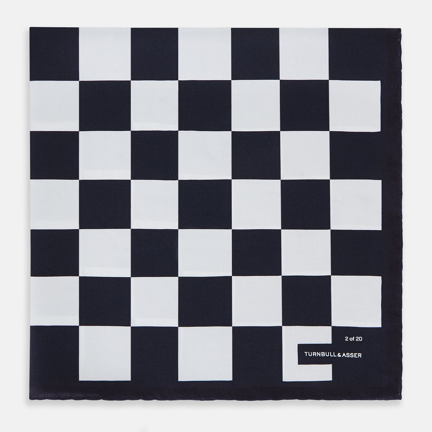 View 1 of product A chequered navy on navy frame silk pocket square from Turnbull & Asser UK, this piece is a limited edition from the Driver’s Capsule Collection, featuring “Turnbull & Asser” and “2 of 20” printed in one corner.