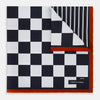 View 1 of product A limited edition silk pocket square from Turnbull & Asser UK, featuring a striking navy chequered pattern framed by a bold red border and finished with the text TURNBULL & ASSER in one corner. Part of the exclusive Driver’s Capsule Collection.
