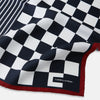 View 2 of product Introducing the Chequered Navy on Red Frame Pocket Square in Silk from Turnbull & Asser UK. This limited edition accessory, part of the Driver’s Capsule Collection, features a bold navy and white checkerboard pattern bordered by deep red silk. The bottom right corner is subtly detailed with white text reading “Turnbull & Asser” and “2 of 20.”.