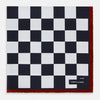 View 1 of product Introducing the Chequered Navy on Red Frame Pocket Square in Silk from Turnbull & Asser UK. This limited edition accessory, part of the Driver’s Capsule Collection, features a bold navy and white checkerboard pattern bordered by deep red silk. The bottom right corner is subtly detailed with white text reading “Turnbull & Asser” and “2 of 20.”.