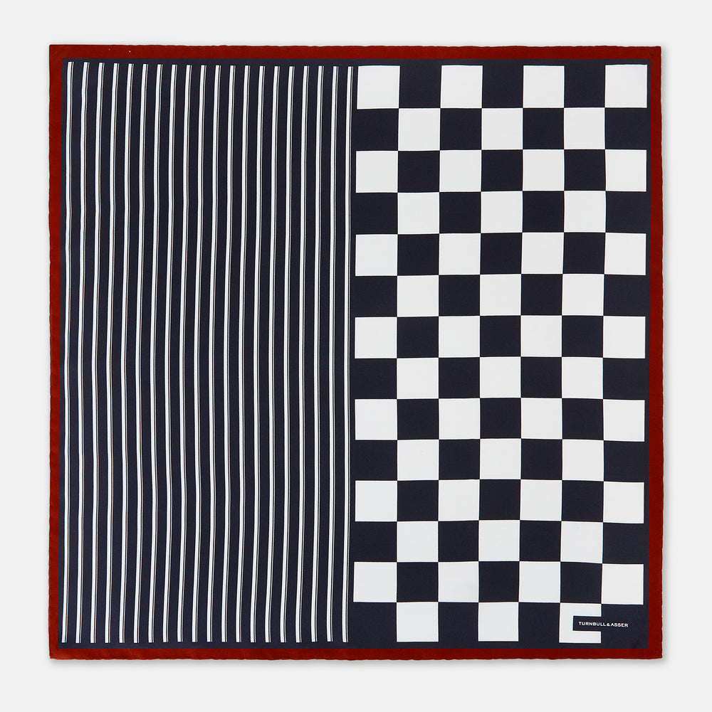 Introducing the Chequered Navy on Red Frame Pocket Square in Silk from Turnbull & Asser UK. This limited edition accessory, part of the Driver’s Capsule Collection, features a bold navy and white checkerboard pattern bordered by deep red silk. The bottom right corner is subtly detailed with white text reading “Turnbull & Asser” and “2 of 20.”.