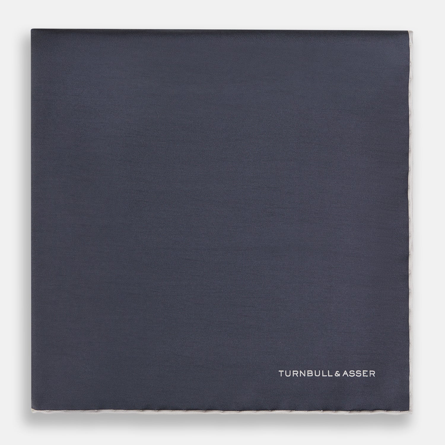 View 3 of product A neatly folded grey silk pocket square with ecru piping—ideal for formal wear—and TURNBULL & ASSER printed in white in one corner.