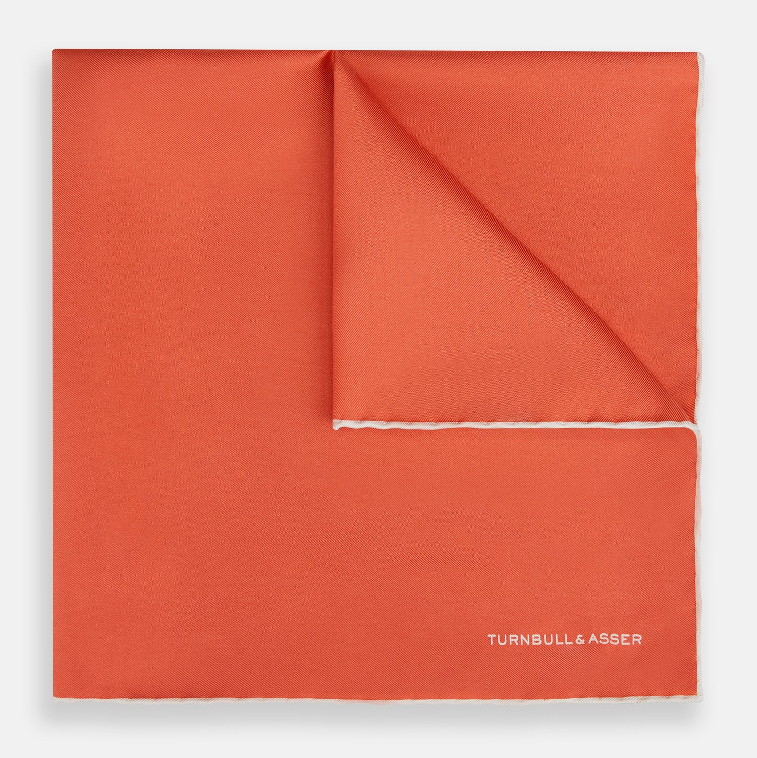 View 1 of product The Orange and White Piped Silk Pocket Square by Turnbull & Asser features a solid orange design with white piping and the brand’s logo in the bottom right corner, making it an elegant addition to any formal outfit.
