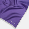 View 2 of product The Turnbull & Asser Violet and Ecru Piped Silk Pocket Square features a stitched edge and white brand logo, making it an elegant addition to formalwear.