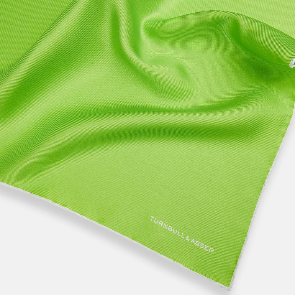 The Lime Green and Ecru Piped Silk Pocket Square by Turnbull & Asser adds a refined touch to any formal look.