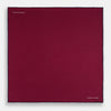 View 4 of product The Mauve Piped Silk Pocket Square by Turnbull & Asser features a dark blue edge and white embroidered logo in the lower right corner, making it ideal for formal occasions. Displayed on a plain white background.