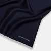 View 2 of product The Midnight Blue Piped Silk Pocket Square from Turnbull & Asser features crisp white trim and subtle branding, making it the ideal accessory to elevate your formal look.