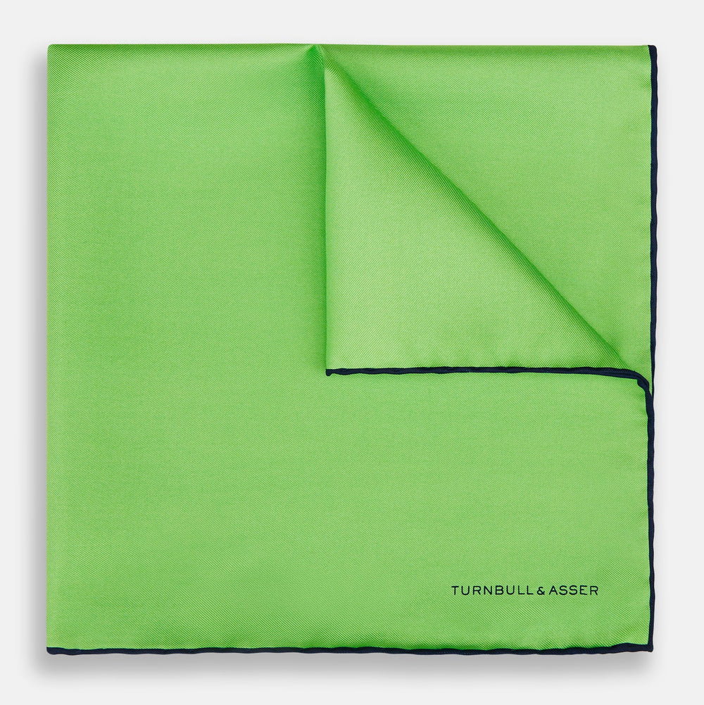 A neatly folded Turnbull & Asser LIGHT GREEN AND BLACK PIPED SILK POCKET SQUARE—ideal for elevating formal attire.