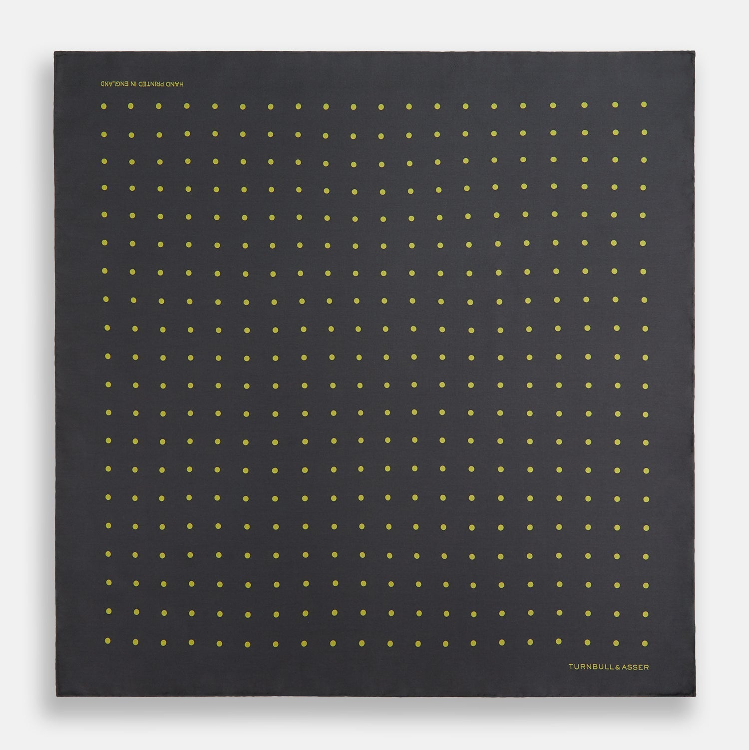 View 4 of product A grey and lime spot silk pocket square by Turnbull & Asser, featuring evenly spaced dots and the brand's logo in one corner—perfect for adding a stylish touch to formal attire.
