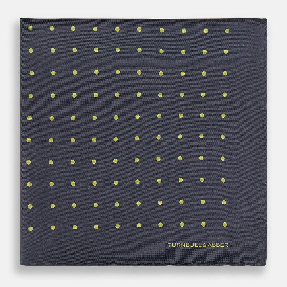 A grey and lime spot silk pocket square by Turnbull & Asser, featuring evenly spaced dots and the brand's logo in one corner—perfect for adding a stylish touch to formal attire.