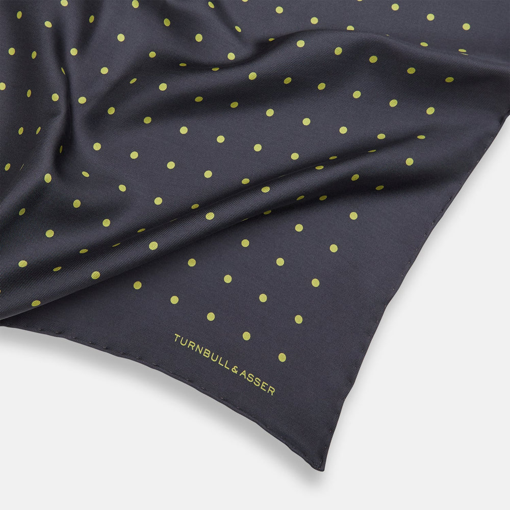 A grey and lime spot silk pocket square by Turnbull & Asser, featuring evenly spaced dots and the brand's logo in one corner—perfect for adding a stylish touch to formal attire.