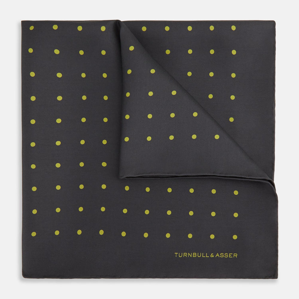 A grey and lime spot silk pocket square by Turnbull & Asser, featuring evenly spaced dots and the brand's logo in one corner—perfect for adding a stylish touch to formal attire.