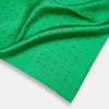 View 2 of product The Green and Navy Spot Silk Pocket Square by Turnbull & Asser features evenly spaced navy spots on green silk, with the brand name printed in the lower right corner and one corner folded over. Ideal for formal wear.