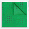 View 1 of product The Green and Navy Spot Silk Pocket Square by Turnbull & Asser features evenly spaced navy spots on green silk, with the brand name printed in the lower right corner and one corner folded over. Ideal for formal wear.